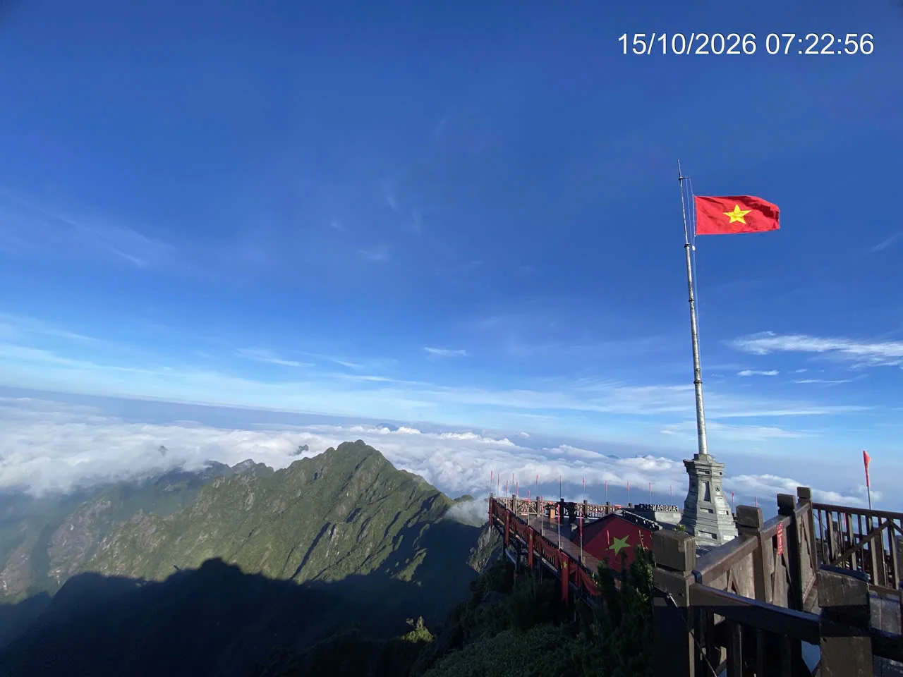 Cột cờ Việt Nam trên đỉnh Fansipan bên các dãy núi và biển mây lúc 07:22 ngày 15/10/2026