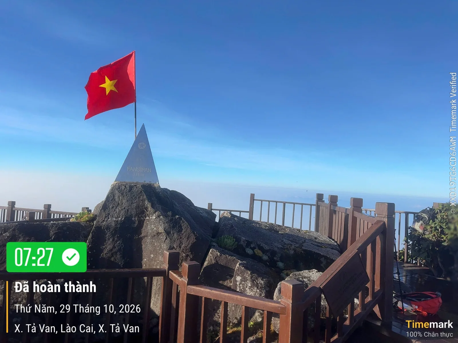 Cột mốc trên khối đá Fansipan lúc 07:27 ngày 29/10/2026: cột mốc và quốc kỳ nổi bật trên nền trời xanh
